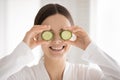Happy funny young woman making cucumber glasses