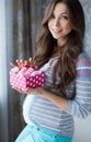 Happy future mother with pink booties in hand Royalty Free Stock Photo