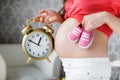 Happy future mother with pink booties in hand Royalty Free Stock Photo