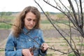 Happy gardener woman using pruning scissors in orchard garden. Pretty female worker portrait