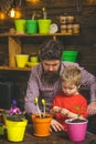 Happy gardeners with spring flowers. bearded man and little boy child love nature. Father and son. Fathers day. Flower