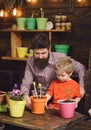 Happy gardeners with spring flowers. Family day. Greenhouse. bearded man and little boy child love nature. Father and Royalty Free Stock Photo