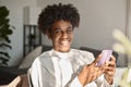 Happy gen z African American teen using mobile phone at home, portrait. Royalty Free Stock Photo