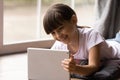 Happy gen Z kid girl watching movie on tablet computer Royalty Free Stock Photo