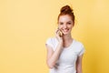 Happy ginger woman in t-shirt talking by the smartphone