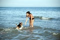 Happy girl playing with a dog on the beach Royalty Free Stock Photo