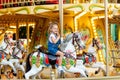 Happy girl in an amusement park rides a horse on a carousel in the summer Royalty Free Stock Photo