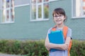 Happy cute girl with backpack and notebooks going to school