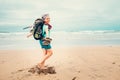 Happy girl backpacker traveler runs barefoot on the sand ocean b