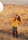 Happy girl with balloon in field