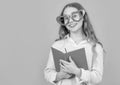 Happy girl in big funny heart-shaped glasses holding school book blue background Royalty Free Stock Photo