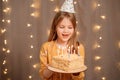 Happy girl with birthday cake. tradition to make wish and blow out fire Royalty Free Stock Photo