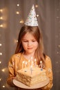 Happy girl with birthday cake. tradition to make wish and blow out fire Royalty Free Stock Photo