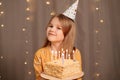 Happy girl with birthday cake. tradition to make wish and blow out fire Royalty Free Stock Photo