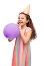 happy girl in birthday party hat blowing balloon Royalty Free Stock Photo