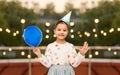 happy girl in birthday party hat blowing balloon Royalty Free Stock Photo