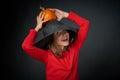 Smiling girl in a black hat holding orange pumpkin Royalty Free Stock Photo