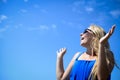Happy girl in black sunglasses on bright blue sky