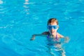 happy girl in blue goggles swimming in the swimming pool Royalty Free Stock Photo