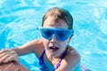 happy girl in blue goggles swimming in the swimming pool Royalty Free Stock Photo