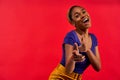 Happy girl in a blue T-shirt in earrings posing at the camera with index fingers pointing to the viewer. Emotions concept