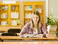 Happy girl with books at the library. Royalty Free Stock Photo