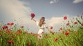 happy girl with bouquet of red flowers. summer vacation and holiday. pretty woman in white dress walking in poppy field Royalty Free Stock Photo