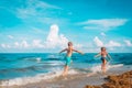 Happy girl and boy run, kids fly and play with waves on beach Royalty Free Stock Photo