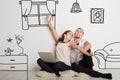 Happy girl with boyfriend imagining their new home interior, collage with doodle furniture drawings on white wall