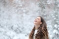 Happy girl breathing fresh air enjoying snow in winter