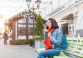 Girl calling on mobile phone sitting on a bench in the street Royalty Free Stock Photo