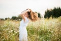 Happy girl on the camomile field, summer sunset. in a white dress. running and spinning, the wind in my hair, life style Royalty Free Stock Photo