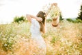 Happy girl on the camomile field, summer sunset. in a white dress. running and spinning, the wind in my hair, life style Royalty Free Stock Photo