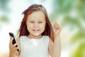 Happy Girl celebrating pumping fist phone in other hand. Beautiful excited surprised little girl having conversation with friends Royalty Free Stock Photo