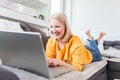 Happy girl chatting online on laptop. Smiling blonde woman messaging with friends on computer. Social media, communication and