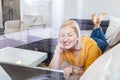 Happy girl chatting online on laptop, window view. Smiling blonde woman messaging with friends on computer. Social media,