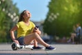 Happy girl child holds smartphone and enjoys sunny summer day sitting on a hoverboard in the park Royalty Free Stock Photo