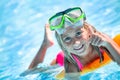 Happy girl child playing in the pool on a sunny day. Cute little girl enjoying holiday vacation Royalty Free Stock Photo