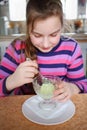 Happy girl child in striped shirt eats ice cream