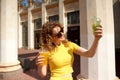 Happy girl chooses lemonade to drink on hot sunny day while walking around city Royalty Free Stock Photo