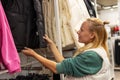 Happy girl chooses winter down jacket in a clothing store Royalty Free Stock Photo