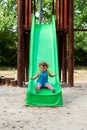 Happy girl chuting down slide at playground Royalty Free Stock Photo