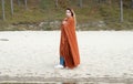 Happy girl Close up portrait. Beautiful lady wearing warm cloth in winter. Brunette woman in the orange scarf smiling. Snowing Royalty Free Stock Photo