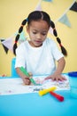 Happy girl coluring into her book Royalty Free Stock Photo