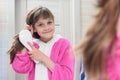 Happy girl combing hair in the bathroom Royalty Free Stock Photo