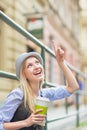 Happy girl with cup of hot beverage pointing on copy space Royalty Free Stock Photo