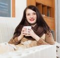 Happy girl with cup near heater Royalty Free Stock Photo