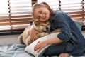 Happy girl with cute Akita Inu dog near window. Little friends Royalty Free Stock Photo