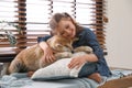 Happy girl with cute Akita Inu dog near window. Little friends Royalty Free Stock Photo