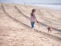 Happy girl with cute dog running on the beach on vacation Royalty Free Stock Photo